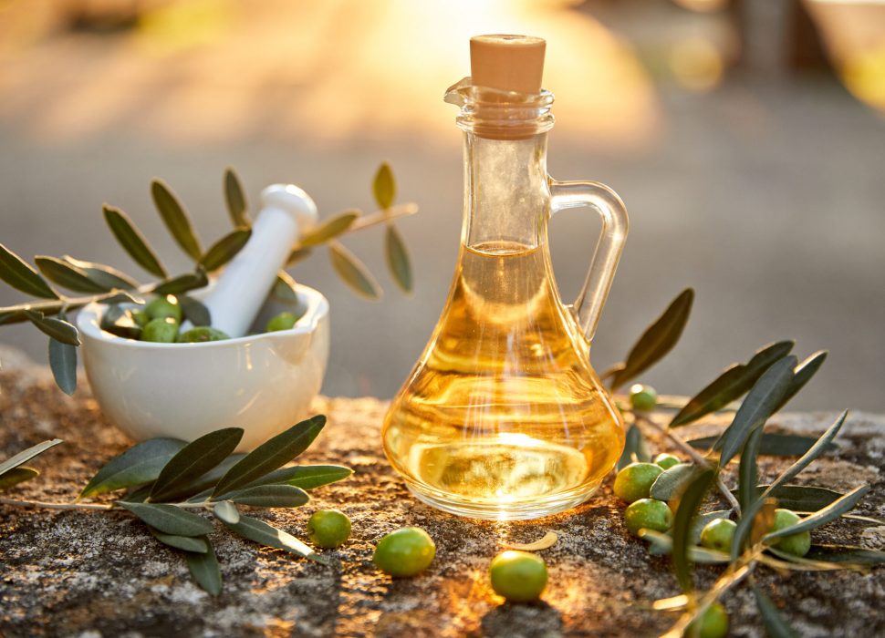 olive oil with fresh olives and leaves